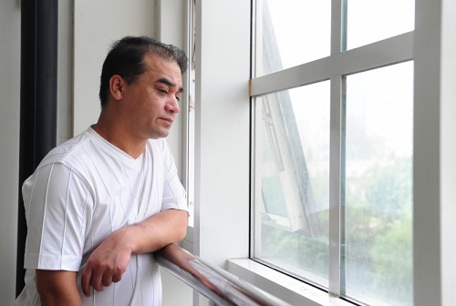 Uygur Türkü profesör İlham Tohti 2010 yılında Pekin'de derse girmeden önce bir pencereden dışarıyı seyrediyor.  (Frederic J. Brown/AFP/Getty Images)