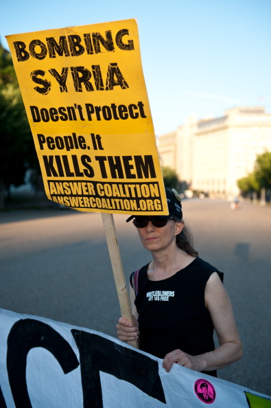 03 09 13- ABD Washington'da beyaz Saray önünde savaş yapılmasını istemeyen eylemci. elindeki pankartta 'Suriye'yi bombalamak onu korumaz, insanları öldürür' yazıyor (NICHOLAS KAMM/AFP/Getty Images)