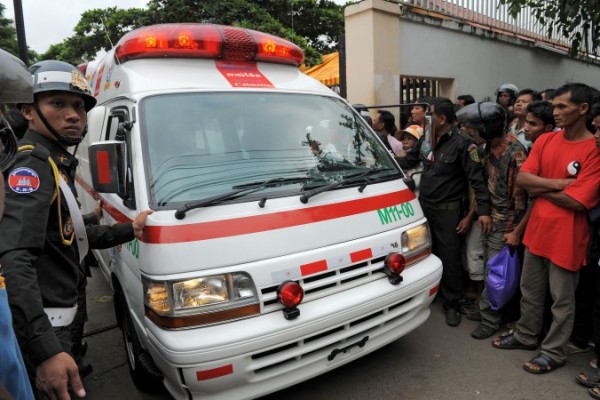 23 Kasım 2010 tarihinde Phnom Penh hastanesinden bir ambulans çıkarken bir polis ona eşlik ediyor. Bu hastane, yapılan baskın sonucu Kamboçya'daki organ ticareti zincirinde bir halka olarak adlandırılmaya başlandı. (Tang Chhin Sothy/AFP/Getty Images)