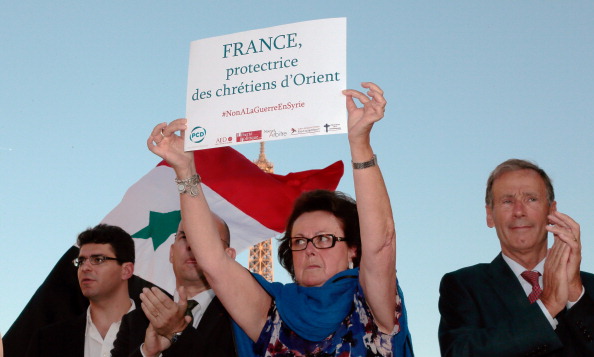 3 Eylül 2013--Fransa Hristiyan Demokratik Parti’nin eski lideri, elinde ‘Fransa Doğu Hristiyanların Koruyucusudur’ yazılı pankartla Suriye’de Beşar El Esad’ın tarafında olduğunu ve savaşın istenmediğini belirtiyor. (JACQUES DEMARTHON/AFP/Getty Images)