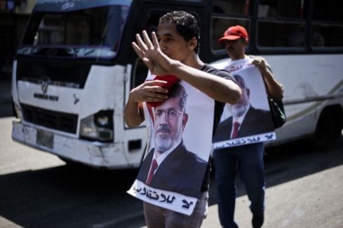 30 Ağustos 2013 Mısır'da Mursi taraftarı elinde Mursi'nin fotoğrafı ile protesto gösterisi yaparken (GIANLUIGI GUERCIA/AFP/Getty Images
