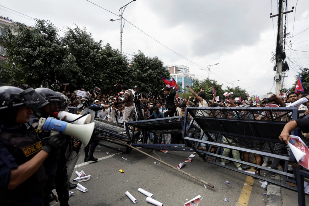 8 Eylül 2025'te Nepal'in Katmandu kentinde, yolsuzluk ve hükümetin çeşitli sosyal medya platformlarını engelleme kararına karşı düzenlenen bir protesto sırasında, göstericiler polis barikatlarını aşmaya çalışıyor.
(Fotoğraf: Navesh Chitrakar/Reuters)