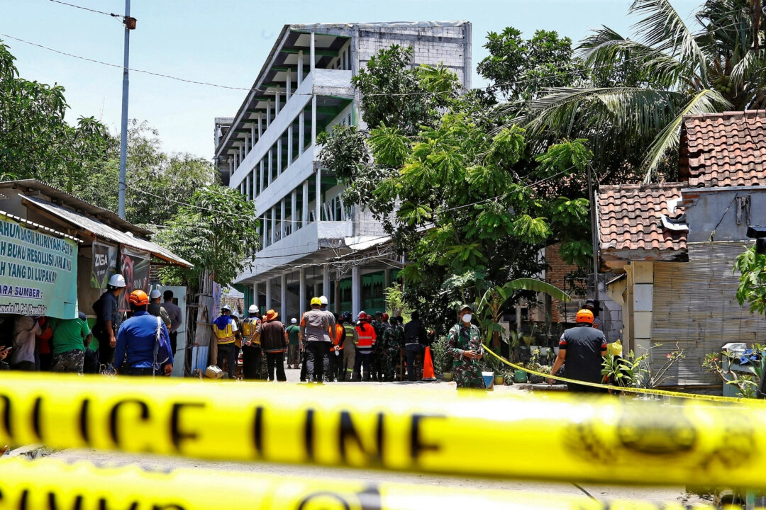 Kurtarma ekipleri, 2 Ekim 2025’te Endonezya’nın Doğu Cava eyaletindeki Sidoarjo’da Al Khoziny İslami yatılı okulunun çöken binasının yanında toplandı. (Fotoğraf: Dipta Wahyu/Reuters)