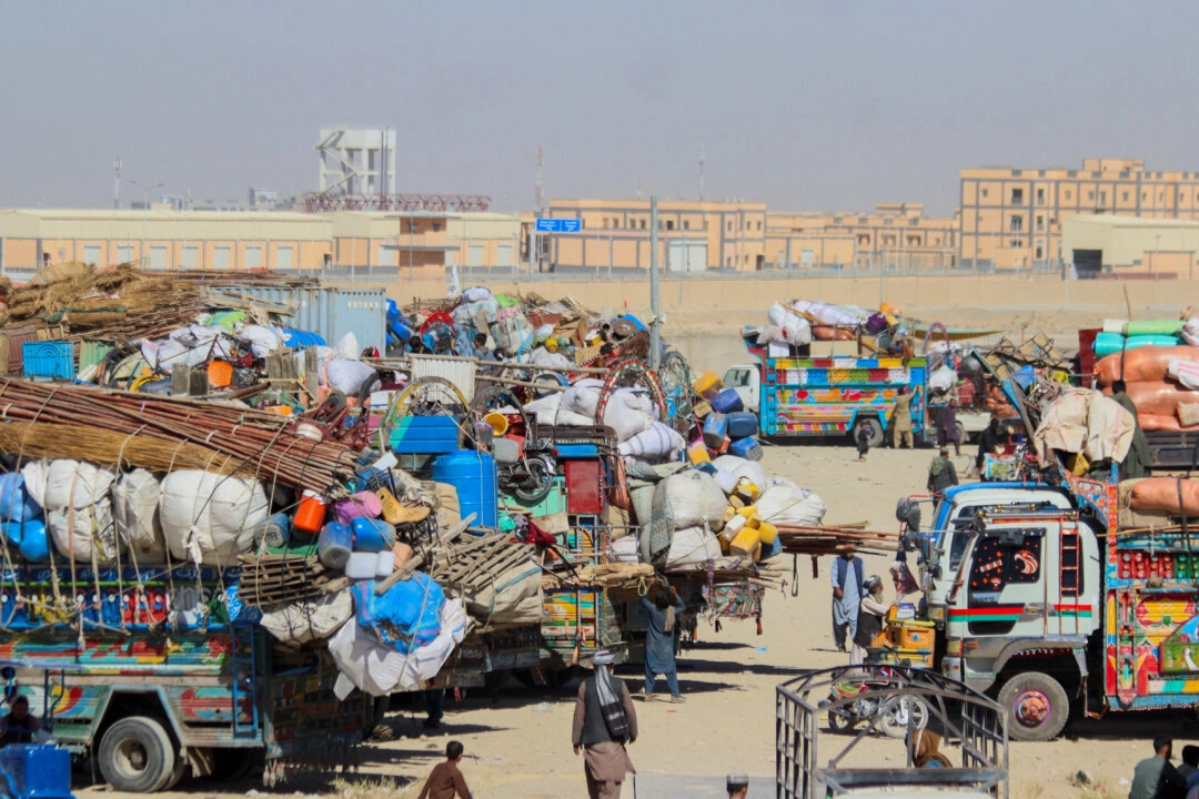 İnsanlar, Pakistan’ın Belucistan Eyaleti’ndeki Pakistan-Afganistan sınırındaki Chaman Sınır Kapısı’nda, iki ülke güçleri arasında yaşanan çatışmaların ardından sınır geçişlerini kapatmasının ardından, Afgan vatandaşlarına ait eşyaların yüklü olduğu park halindeki araçların yanından geçerek ülkelerine geri dönüyor, Chaman, Pakistan, 12 Ekim 2025. (Fotoğraf: Saeed Ali Achakzai/Reuters)