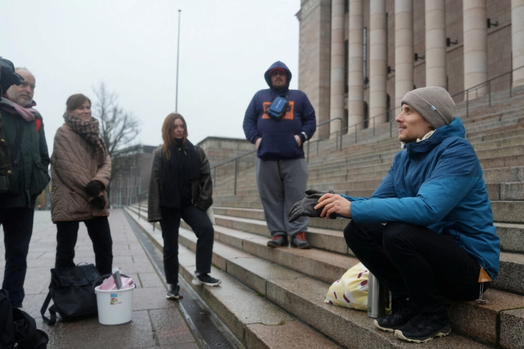 Juho-Pekka Palomaa, 33 yaşında, 30 Ekim 2025'te Helsinki, Finlandiya'da Parlamento binası önünde 1000. işsizlik günü anısına bir potluck protestosu düzenleyerek basamağa oturuyor. (Fotoğraf: Tom Little/Reuters)