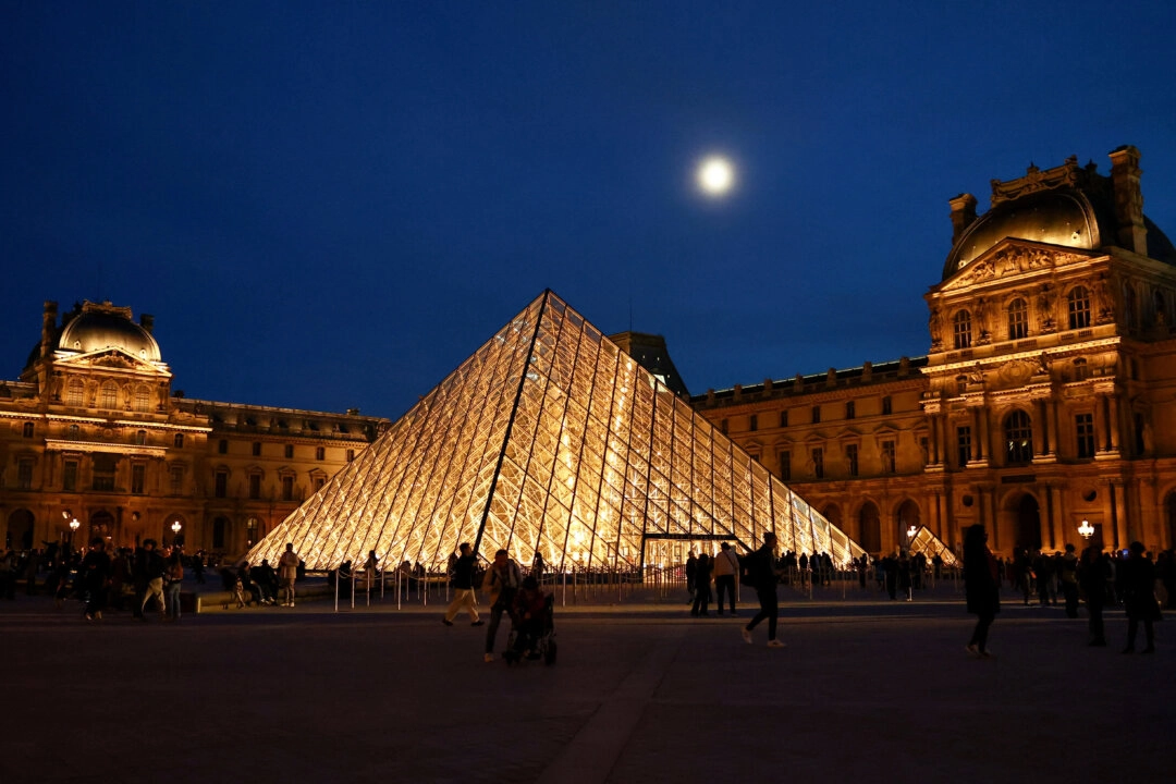 Ziyaretçiler, 30 Ekim 2025'te Paris, Fransa'daki Louvre Müzesi'nin Apollo Galerisi'nden çalınan hazinelerle bağlantılı daha fazla şüphelinin tutuklanmasının ardından, müzenin cam piramidi yakınlarında yürürken. (Fotoğraf: Abdul Saboor/Reuters)