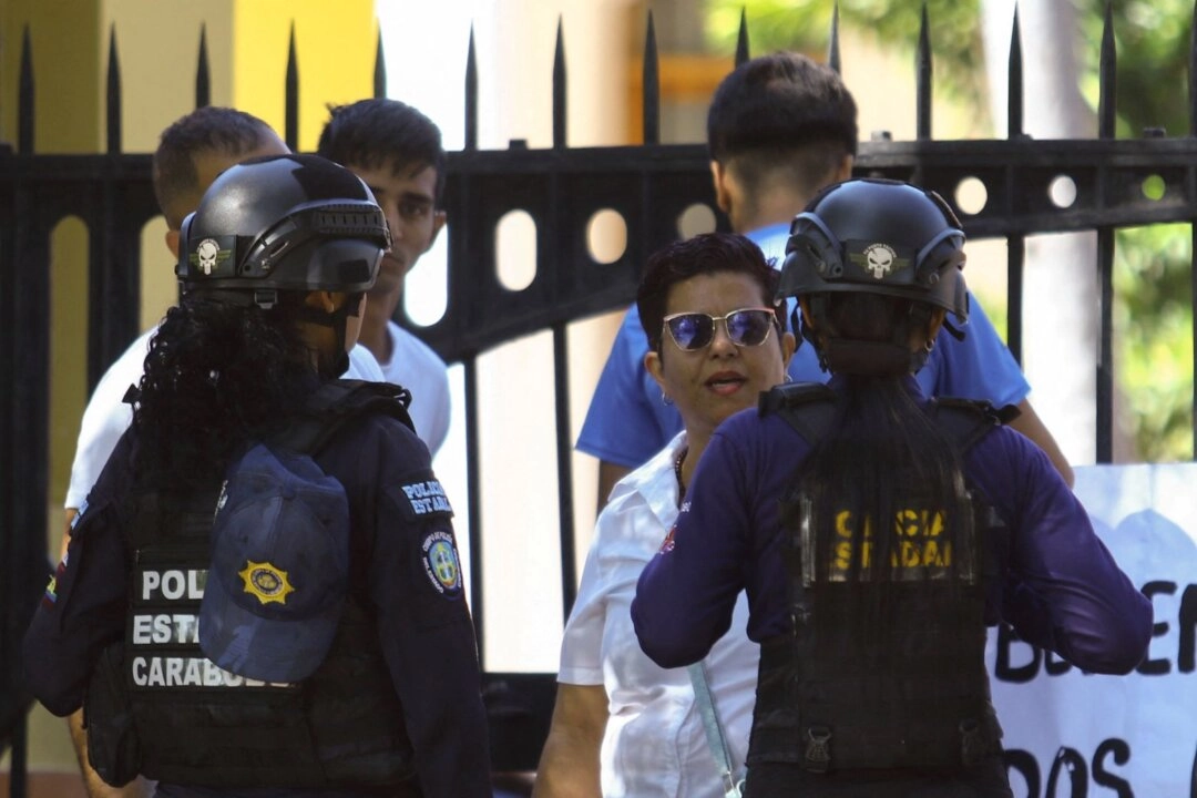 Venezuela geçici yönetimi 626 mahkumun serbest bırakıldığını açıkladı. ABD’nin Nicolás Maduro’yu yakalamasının ardından Venezüella rejimi çok sayıda mahkumu tahliye etti. Carabobo Üniversitesi öğrencileri rektörlük binası önünde, siyasi mahkumların serbest bırakılması için gösteri düzenledi. Protesto sırasında bir polis memuru, bir siyasi mahkumun yakınıyla konuşuyor. 23 Ocak 2026, Valencia, Venezuela. (Fotoğraf: The Epoch Times aracılığıyla, Juan Carlos Hernandez, Reuters)