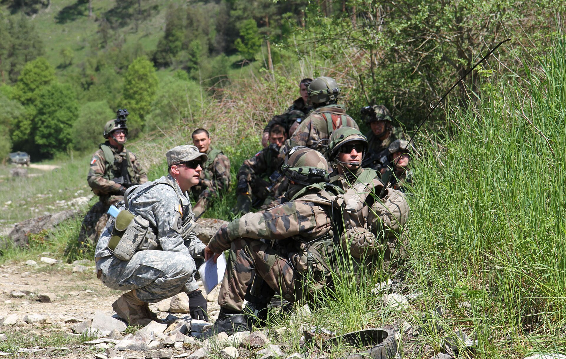 Combined Resolve II, ABD Avrupa Kara Kuvvetleri tarafından yönetilen, Almanya eğitim alanlarında gerçekleştirilen bir tatbikattır. Bir ABD Kara Kuvvetleri gözlemci kontrolörü, tatbikatın ardından Fransız 126. Piyade Alayı üyeleriyle konuşurken. 19 Mayıs 2014, Hohenfels, Almanya. (Fotoğraf: ABD Kara Kuvvetleri Çvş. Bethany E. McMeans, Wikimedia)