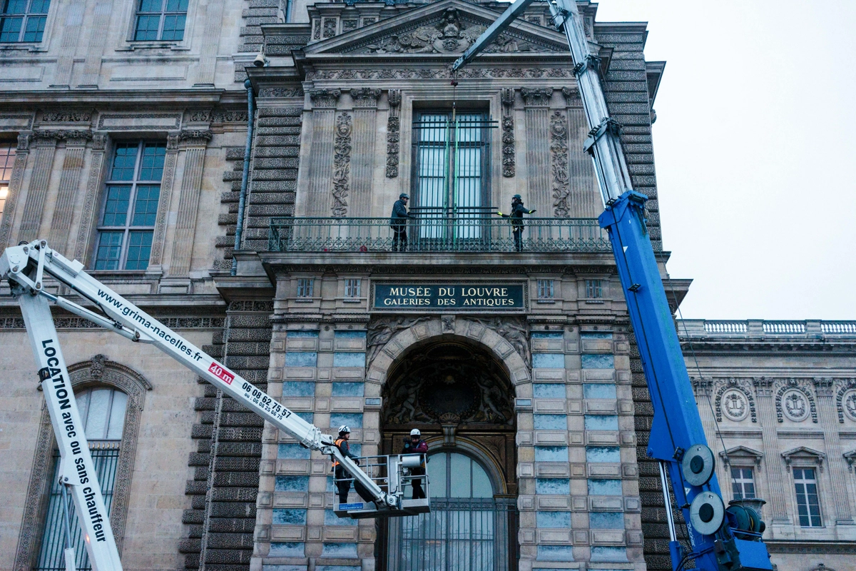 Europol, Avrupa’daki müze soygunlarında şiddetin arttığını açıkladı. İşçiler, Louvre Müzesi'nin Quai François Mitterrand tarafındaki Apollo Galerisi penceresine demir parmaklıklar takarken. 23 Aralık 2025, Paris. (Fotoğraf: Dimitar Dilkoff, AFP - Getty Images, The Epoch Times aracılığıyla)