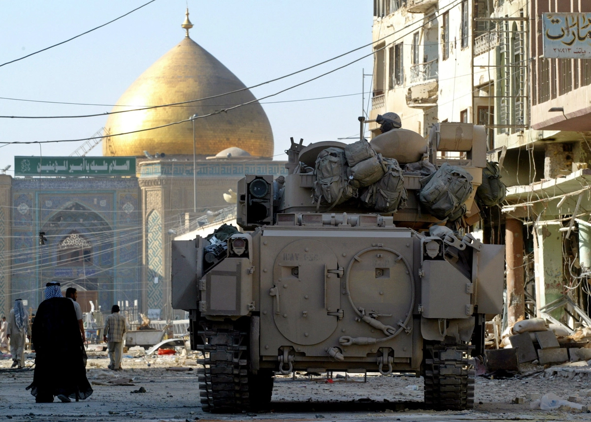 ABD askerleri 30 Eylül’e kadar Irak’taki üslerden çekilecek. 1 Ekim’den itibaren güvenlik sorumluluğunu  Irak devralacak. ABD Kara Kuvvetleri’ne ait bir Bradley zırhlı aracı, 27 Ağustos 2004’te Irak’ın Necef kentinde mezarlıktan İmam Ali Türbesi’ne uzanan yolu koruyor. (Fotoğraf: Chris Helgren, Reuters, The Epoch Times aracılığıyla)