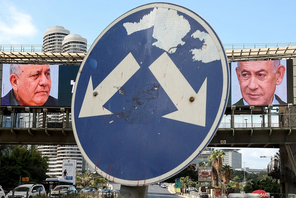 20 Ekim 2026’da Tel Aviv’in Ramat Gan bölgesinde, Likud Partisi lideri ve İsrail Başbakanı Binyamin Netanyahu (sağda) ile eski Genelkurmay Başkanı ve Yashar Partisi lideri Gadi Eisenkot’un (solda) yer aldığı büyük bir reklam panosunun önünde yol tabelası görülüyor. (Fotoğraf: Jack Guez/AFP via Getty Images)